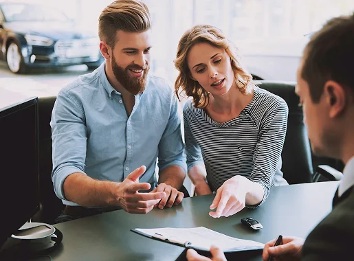 Couple discutant d'un contrat de voiture avec un vendeur dans un showroom Les Essarts-le-Roi dans les Yvelines 78